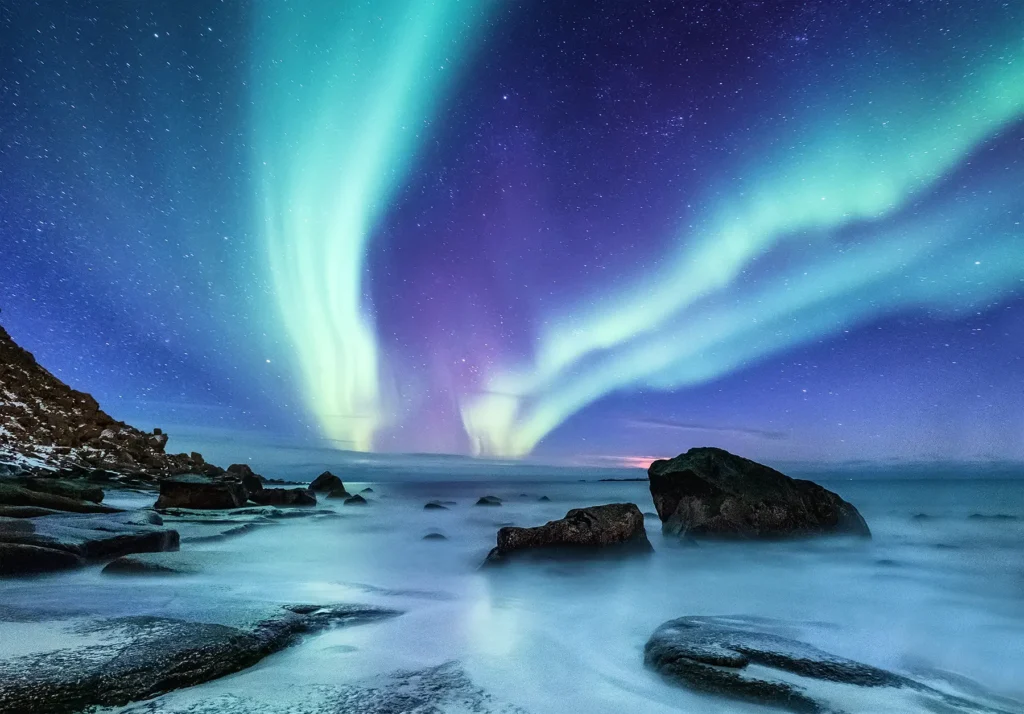 Pristine beach with Northern Lights illuminating the night sky